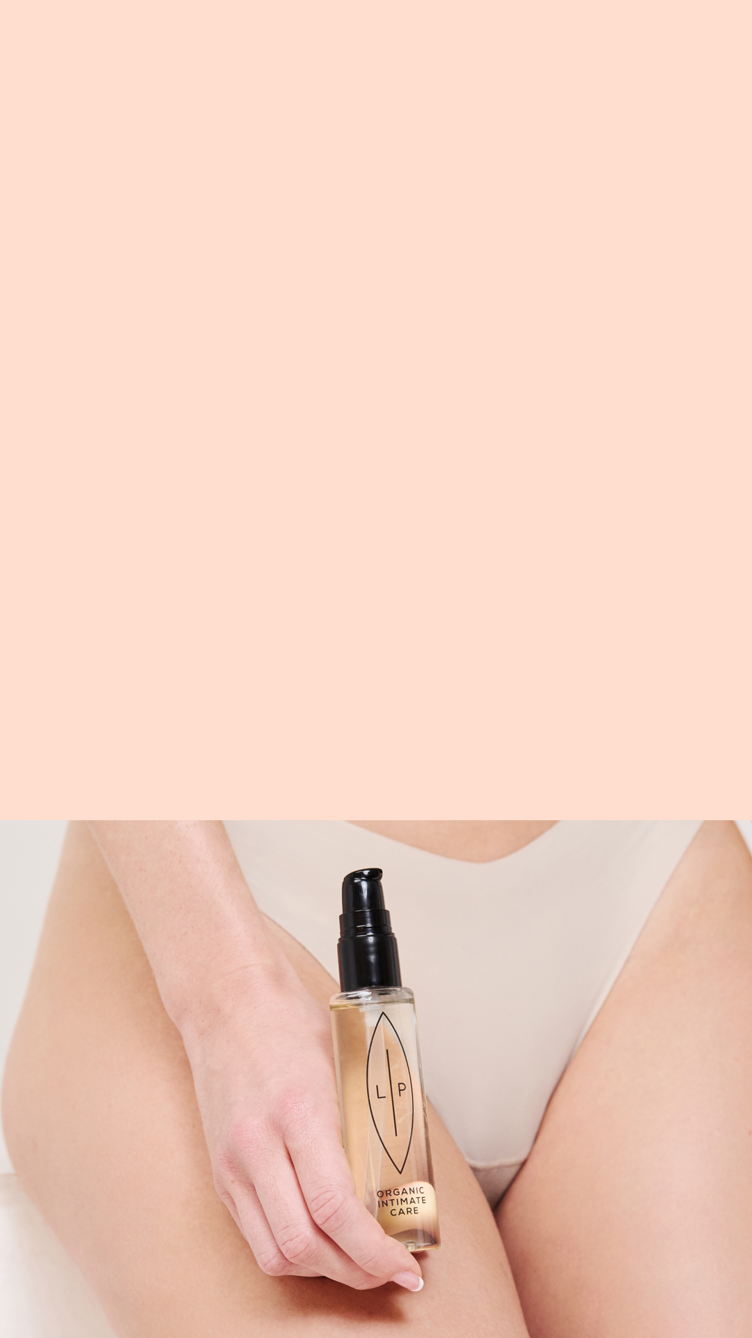 Hand holding a bottle with oil against a beige background